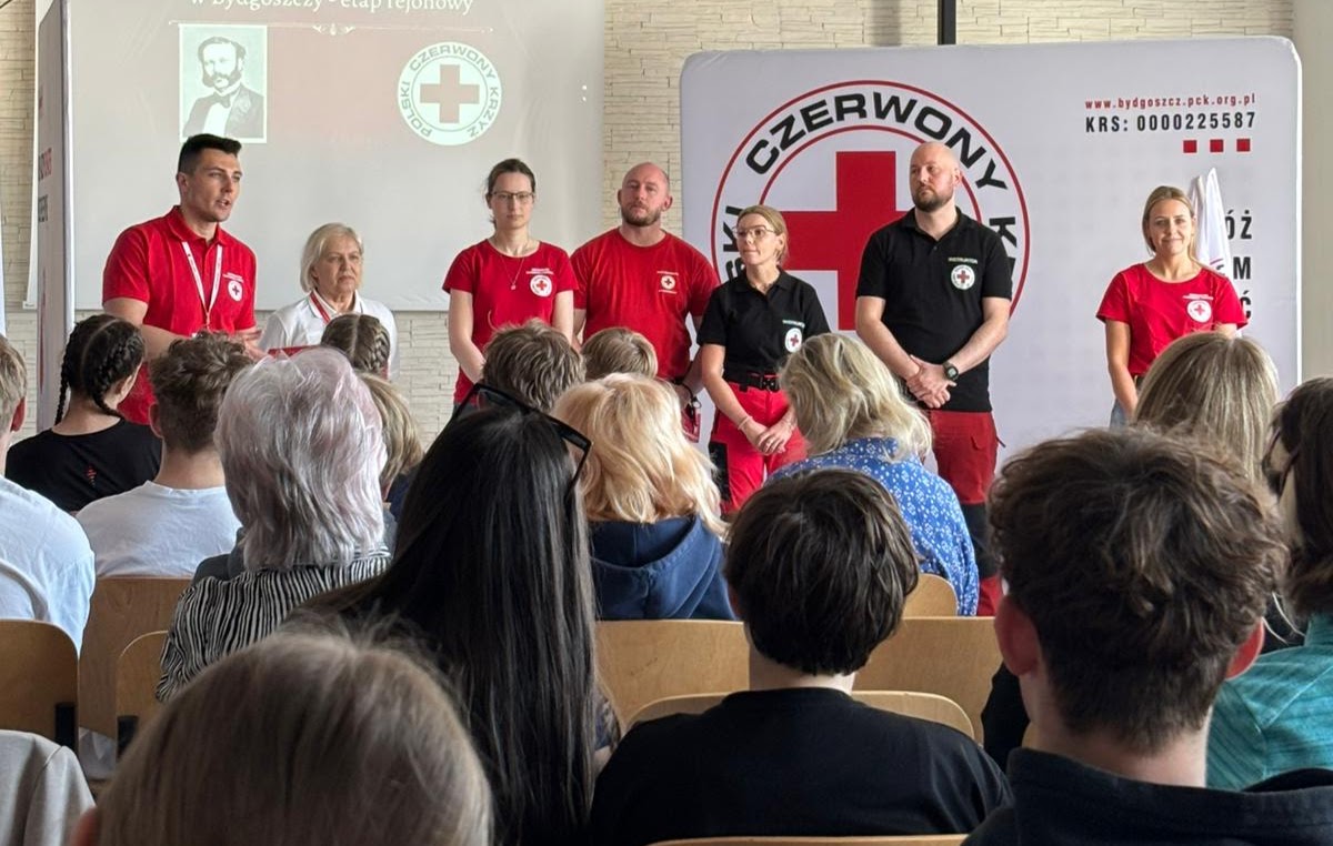 Grupa wolontariuszy Polskiego Czerwonego Krzyża prowadzi prelekcję dla publiczności.