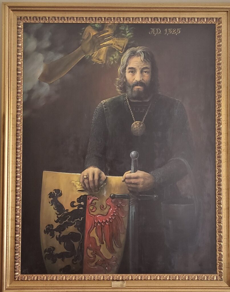 Portret rycerza z mieczem i tarczą herbową, powyżej złota ręka i data AD 1225.